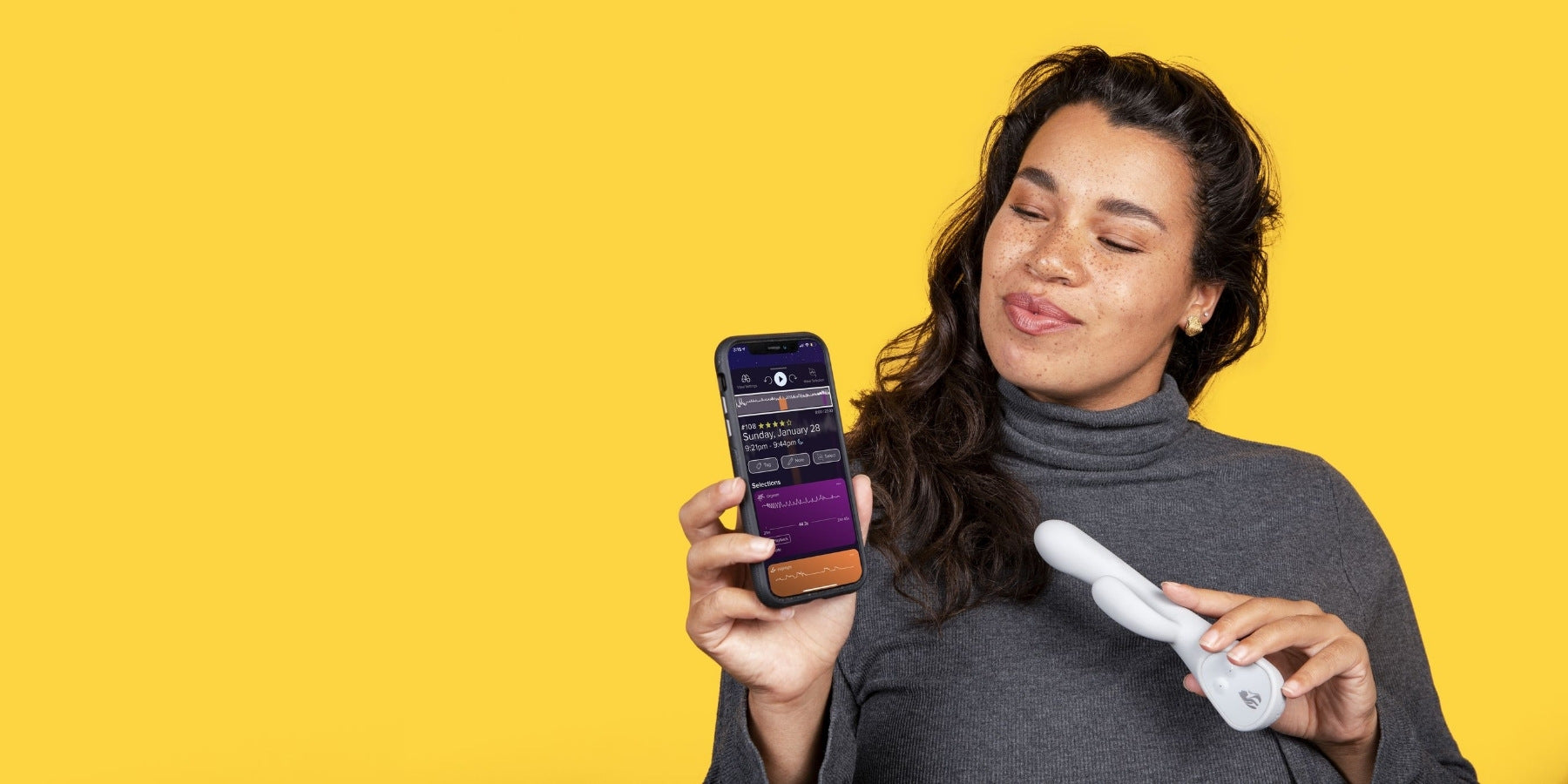 Woman holding grey Lioness Smart Vibrator and App